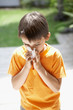 Little Boy Blowing His Nose in back yard