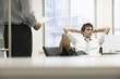 Disinterested businessman reclining on chair and ignoring boss in office