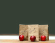 Lunch bags on desk with red apples