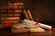 Pile of old books with glasses on desk