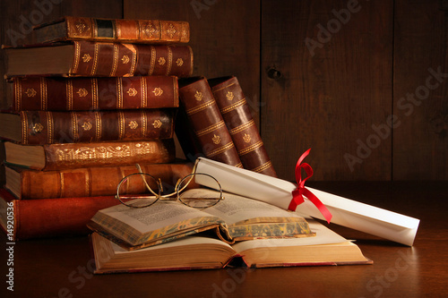 Photo: Pile of old books with glasses on desk Pile of old books with glasses on desk