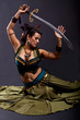 Attractive bellydancer in tribal costume and holding sword Attractive bellydancer in tribal costume and holding sword