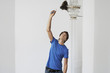 Man dusting crystal chandelier in home