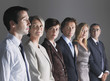 Foto: Group of Businesspeople in a row looking at businessman Group of Businesspeople in a row looking at businessman