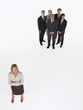 Foto: Businesswoman standing apart from group Businesswoman standing apart from group