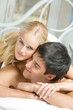 Portrait of young happy amorous couple in bedroom