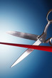 Scissors cutting red ribbon in studio
