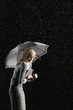 Businesswoman hunching down Under Umbrella for protection from rain