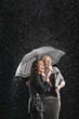 Smiling Businesswomen Standing Under Umbrella together during rain