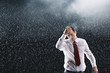Businessman running hands through wet hair, standing in the Rain
