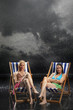 Sunbathers sitting in sunloungers during downpour