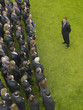 Photo: Business man facing large group of business people in formation, elevated view Business man facing large group of business people in formation, elevated view
