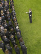Photo: Business woman facing large group of business people in formation, elevated view Business woman facing large group of business people in formation, elevated view