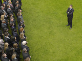 Photo: Business man facing large group of business people in formation, elevated view Business man facing large group of business people in formation, elevated view