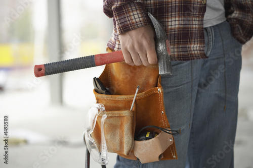 Photo: Construction worker wearing tool belt, mid section Construction worker wearing tool belt, mid section
