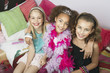 Girls sitting, arms around one another on trendy sofa at a Slumber Party, high angle view