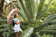Girl Looking at Large Fern