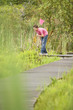 Boy Looking for Wildlife in Marsh