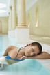 Young woman leaning on edge of swimming pool, portrait