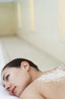 Young woman with salts on back lying on massage table, portrait