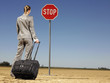 Businesswoman in Desert Looking at Stop Sign
