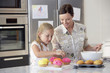 Mother and Daughter Making Cupcakes in kitchen