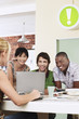 Foto: Four people having meeting around laptop, laughing. Four people having meeting around laptop, laughing.