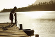Boy 7-9 standing on dock, pulling in float tube. 