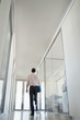 Businessman Walking in Corridor, low angle back view.