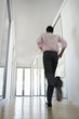 Businessman Running in Corridor, low angle back view.