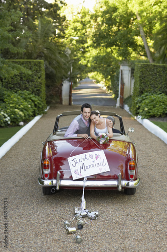 Photo: Portrait of newlyweds in vintage convertible Portrait of newlyweds in vintage convertible