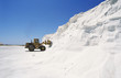 Digger truck advancing into wall of snow