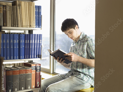 Photo: College Student Reading in Library College Student Reading in Library