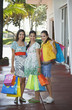 Photo: Three teenage girls 16-17 carrying shopping bags, standing on street, portrait Three teenage girls 16-17 carrying shopping bags, standing on street, portrait