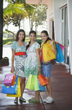 Photo: Three teenage girls 16-17 carrying shopping bags, standing on street, portrait Three teenage girls 16-17 carrying shopping bags, standing on street, portrait