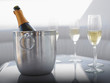 Flutes and champagne in ice bucket on table