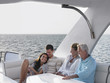 Young and middle-aged couple relaxing on yacht