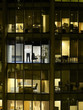 Business man holding up blank paper in office, view from building exterior