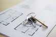 Key ring with three keys lying on architectural blueprint, close-up