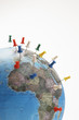 Push pins in various parts of globe, studio shot