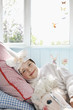 Photo: Portrait of young girl 5-6 lying on bed in unicorn costume with toy horse, smiling Portrait of young girl 5-6 lying on bed in unicorn costume with toy horse, smiling