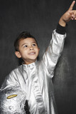 Photo: Portrait of young boy 5-6 in astronaut costume, pointing upwards, smiling, studio shot Portrait of young boy 5-6 in astronaut costume, pointing upwards, smiling, studio shot
