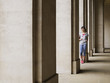Foto: Woman standing against column in portico Woman standing against column in portico