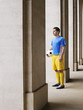 Foto: Soccer player holding ball, standing in portico Soccer player holding ball, standing in portico