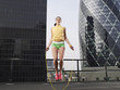 Foto: Woman skipping on skipping rope on downtown rooftop, low angle view, London, England Woman skipping on skipping rope on downtown rooftop, low angle view, London, England