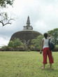 Young woman looking at stupa, back view