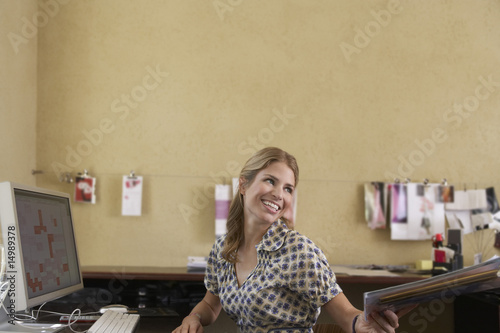 Photo: Woman handing off papers in office Woman handing off papers in office
