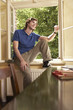 Young man sitting on sill of living room window