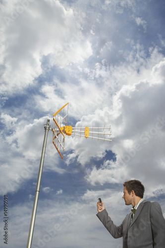 Foto: Business man pointing cell phone at aerial Business man pointing cell phone at aerial