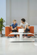 Two people using laptop in reception room